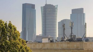 Stadsgezicht met moderne wolkenkrabbers, waaronder een opvallend gebouw met een 'Santander'-bord.
