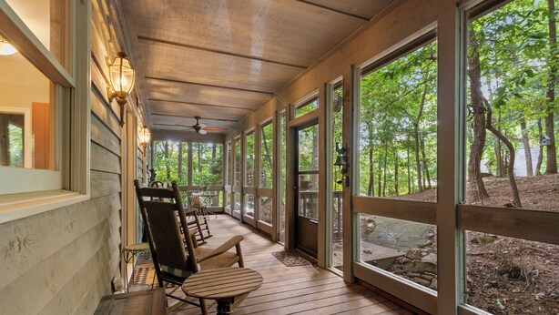 A covered porch with wooden flooring, large windows, and outdoor seating. - Cozy Mountain Getaway in Big Canoe (Big Canoe)