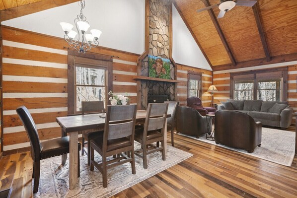 L’intérieur d’une cabane en rondins comprend un coin repas, une cheminée et un salon confortable.