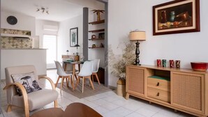Un salon moderne comprenant un coin repas, un canapé, une table basse et un buffet agrémenté d’objets décoratifs.