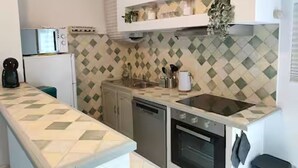Une cuisine compacte équipée d’un four à micro-ondes, d’un four traditionnel et d’un lave-vaisselle.