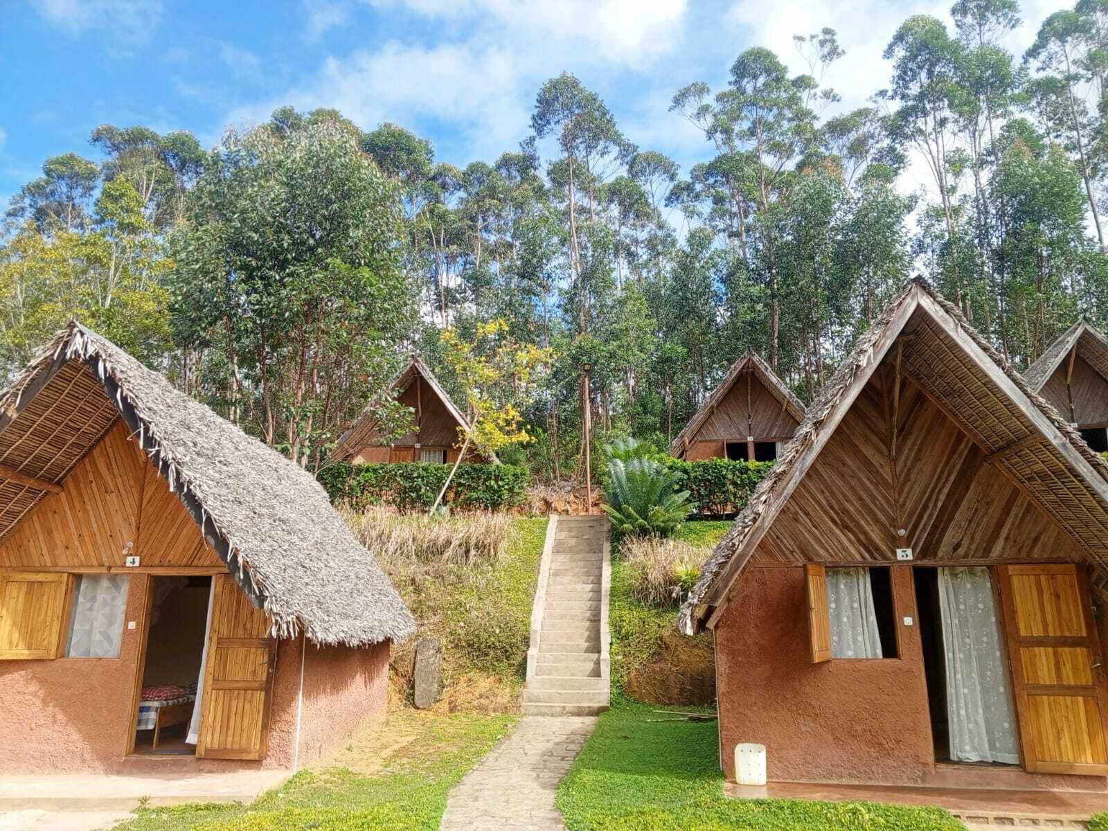 Un hilera de casas de campo con techo de paja, con una escalera central que conduce a un nivel superior.