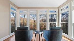 A room with a large bay window, two armchairs, and a small table. - Thrush Turn Manor in Big Canoe with a hot tub (Jasper)
