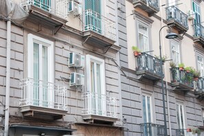 Un immeuble à plusieurs étages doté de balcons, de climatiseurs et de plantes en pot.
