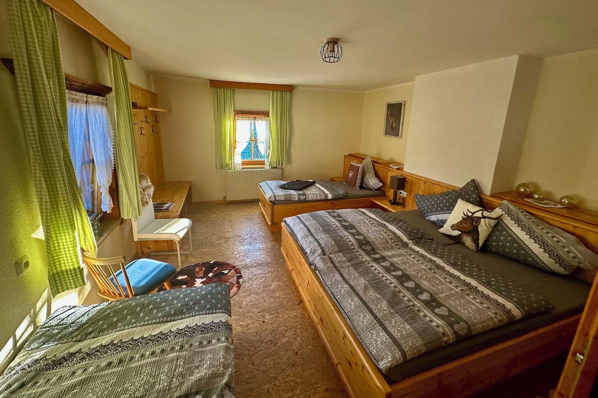 A cozy room with two beds, a desk, and a chair.