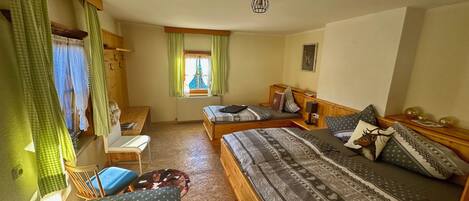 Een gezellige kamer met twee bedden, een bureau en een stoel.