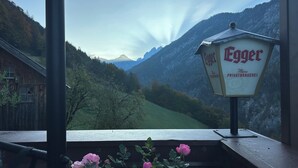 Vue d’une vallée de montagne avec un panneau indiquant le vin « Egger ».