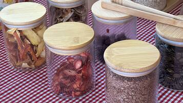 Several glass jars with wooden lids on a checkered tablecloth.