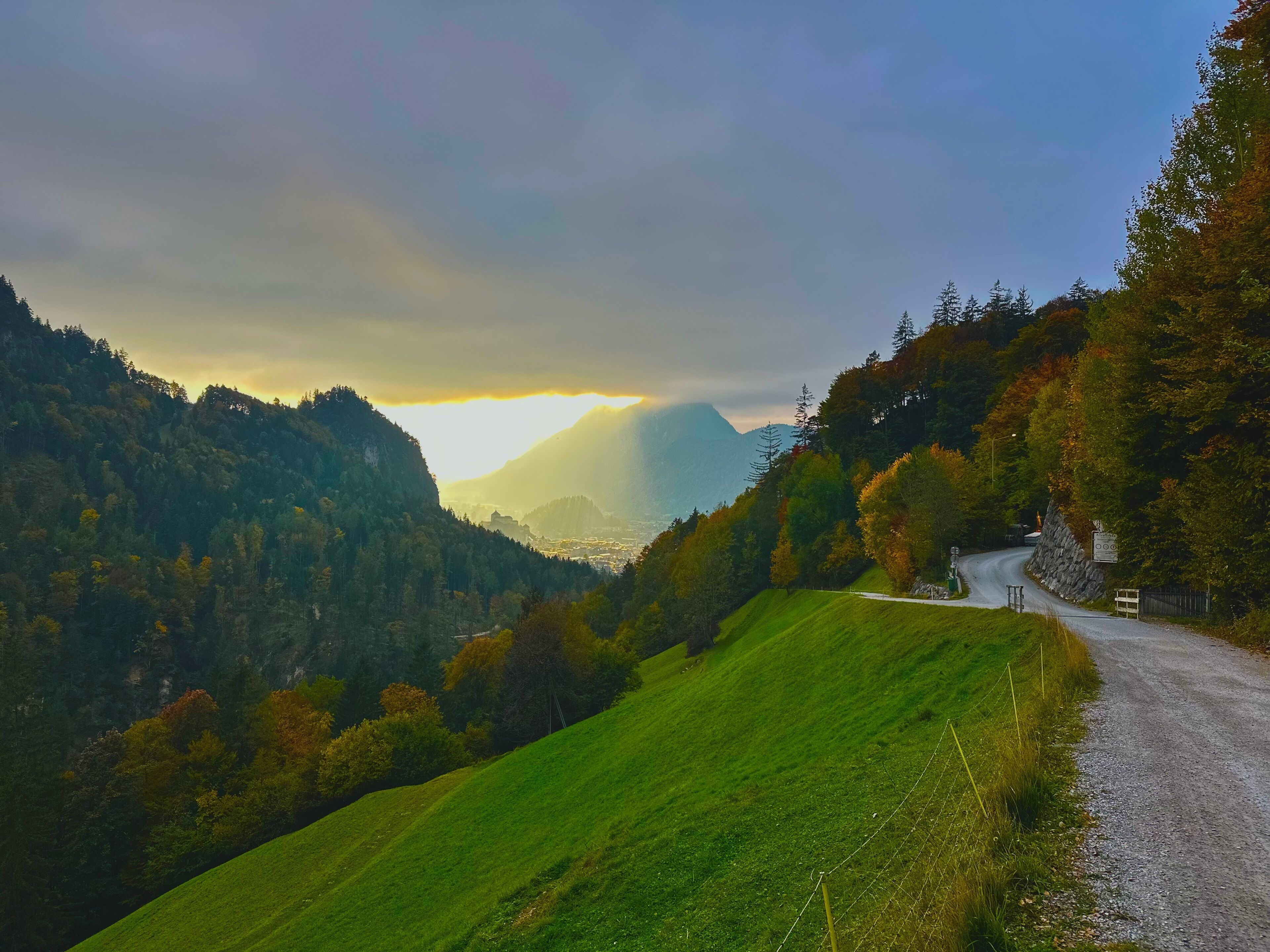 Een kronkelende weg door een bergachtig landschap, met zicht op een verafgelegen bergketen.