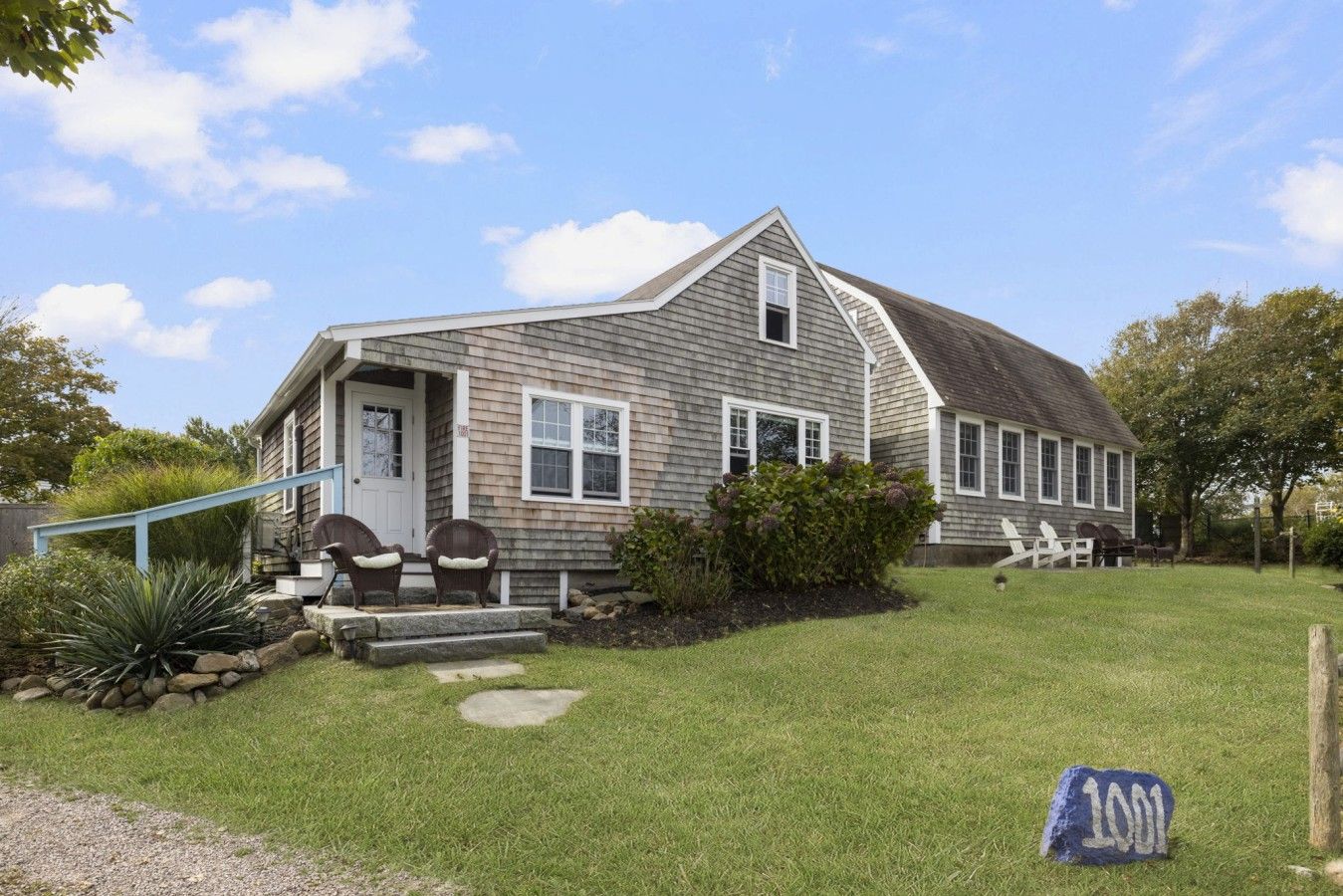 A single-story house with a front porch, a mailbox, and a number sign.