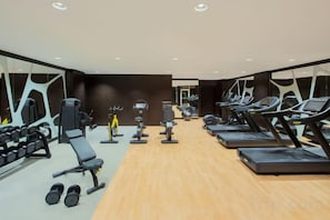 A gym with treadmills, dumbbells, and weight machines. - DoubleTree by Hilton Doha - Al Sadd (Doha)