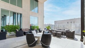 A modern outdoor lounge area with seating and potted plants.