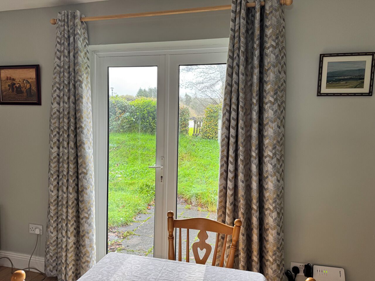 A room with a bed, a chair, and a door leading to a garden.