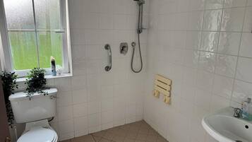 A bathroom with a toilet, a shower, and a sink.