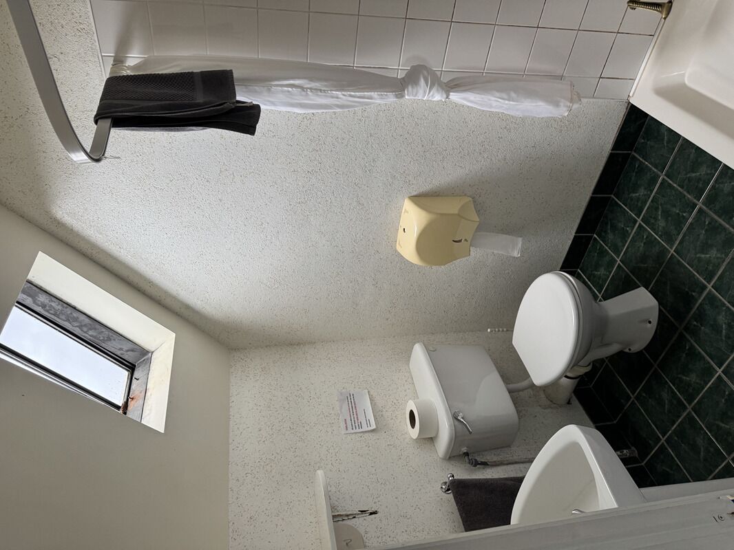 Un baño con inodoro, bidé y ventana.