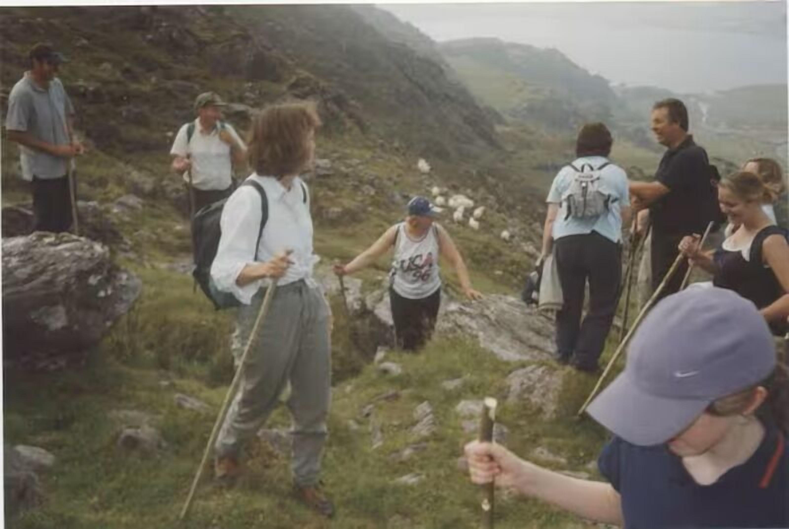 A group of people hiking on a rocky mountain trail.