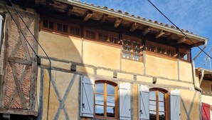 A two-story building with a yellow facade and a traditional timber frame design.