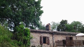 A rustic stone building with a tiled roof, wooden shutters, and a balcony with a wooden railing. - Aymes - VAOUR - Gîte (VAOUR)