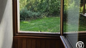 A room with a large window overlooking a lush green garden. - Aymes - VAOUR - Gîte (VAOUR)
