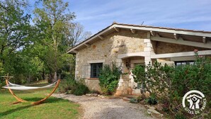 A stone building with a garden and a hammock. - La Montarnaude - PUYCELSI (PUYCELSI)