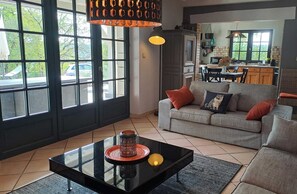 Una sala de estar con sofá, mesa de centro y un comedor con sillas y una mesa.