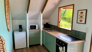 A compact kitchen with a microwave, coffee maker, and sink.