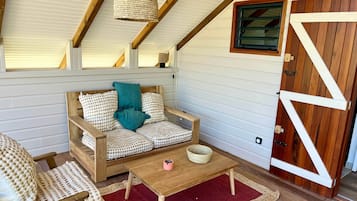Une pièce chaleureuse avec un canapé en bois, une petite table et un tapis rouge.