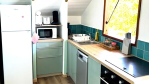 Cocina compacta equipada con refrigerador, microondas, tostadora, pileta y lavavajillas.