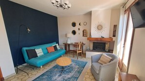 A living room with a blue sofa, a grey armchair, a coffee table, and a fireplace.