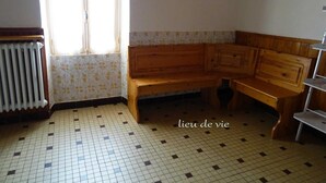 A room with a tiled floor, a wooden bench, a radiator, and a window.
