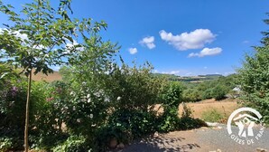 A rural landscape with a gravel path, lush greenery, and rolling hills in the background. - La Bruninquillé - MONTREDON-LABEISSONNIE (MONTREDON-LABEISSONNIE)