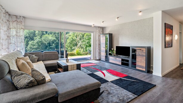 A modern living room with a sofa, coffee table, and TV stand. - Apartment 'Burkhardt' with Mountain View, Private Terrace and Wi-Fi (Bad Herrenalb)
