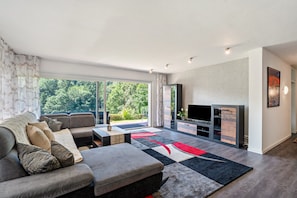 Een moderne woonkamer met een bank, salontafel en tv-meubel.