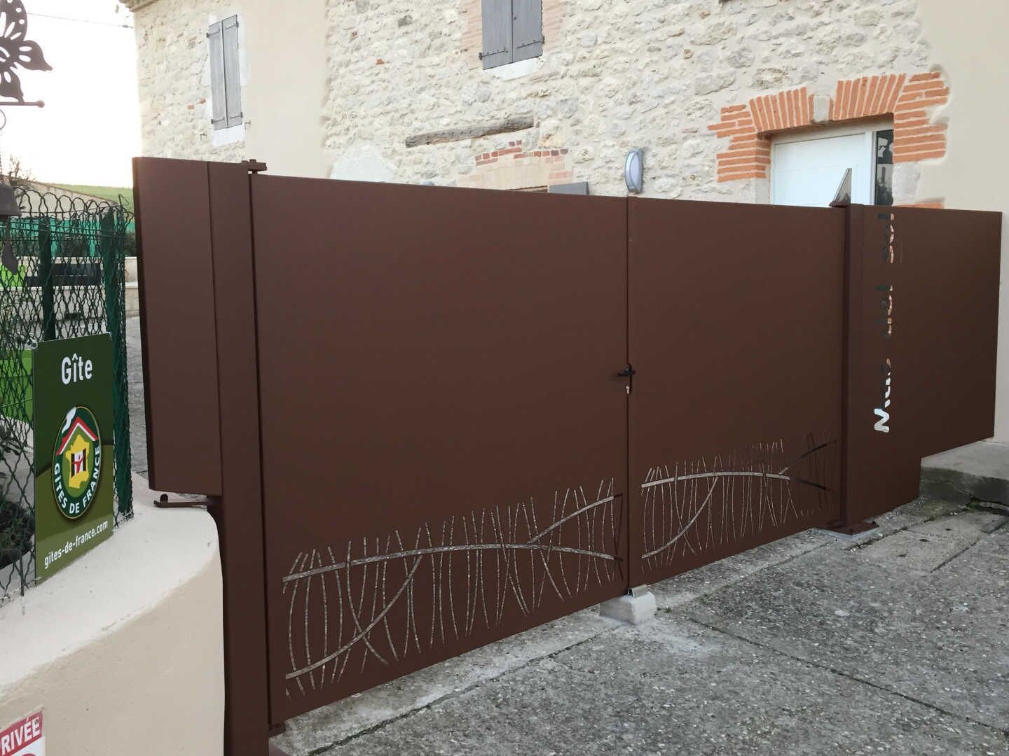 Una entrada protegida con una reja de metal y un cartel de Gîte de France.