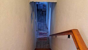 Una escalera de madera con barandilla que da a un rellano.