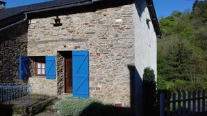 A stone building with blue shutters, a metal gate, and a wooden fence. - Gîte 42 - LACAUNE - Gîte (LACAUNE)