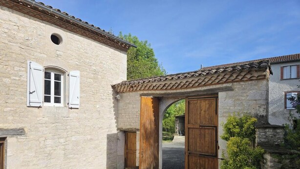 A stone building with a tiled roof, a wooden door, and a window with shutters. - La Falgarié - VIRAC - Gîte (VIRAC)