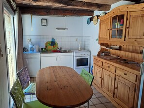 A kitchen with a wooden table, cabinets, and a stove. - Crameaux - SAINT-ANDRE (SAINT-ANDRE)
