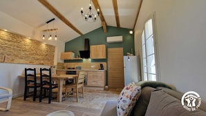 A cozy kitchen with wooden cabinets, a dining table with chairs, and a built-in oven. - Le Chinchilla - GAILLAC (GAILLAC)
