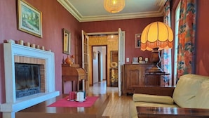 Uma sala de estar acolhedora com lareira, sofá, mesa de centro e abajur.