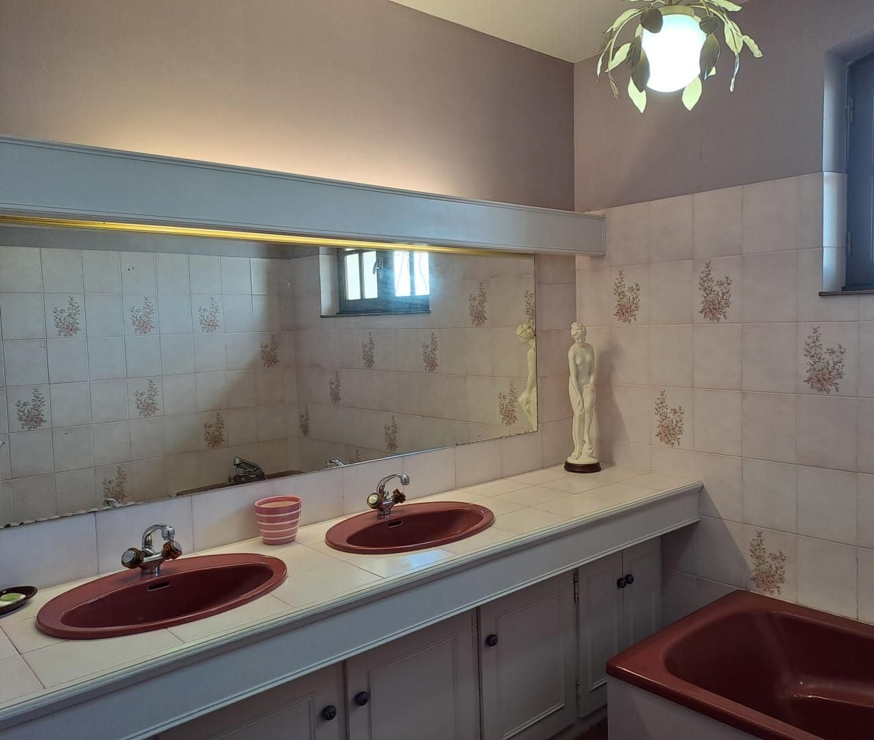 Une salle de bain avec deux lavabos, un grand miroir et une baignoire.