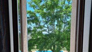 A balcony with a view of a swimming pool and trees.