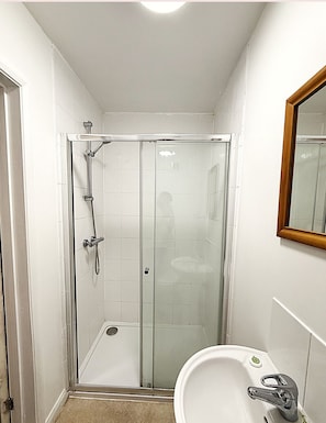 Een douche, handdoeken, zeep, shampoo