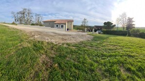 A house with a tiled roof, a paved driveway, and a grassy yard. - Les Acacias d'En Cassé (LAVAUR)