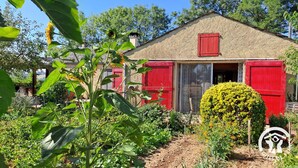 A rustic house with red shutters, surrounded by lush greenery and a well-maintained garden. - Au pré vert - SAINT PIERRE DE TRIVISY (SAINT PIERRE DE TRIVISY)