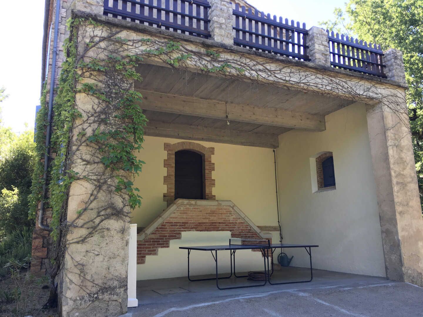 A building with a brick staircase, a small window, and a metal table in the foreground.