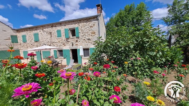 Un bâtiment en pierre avec un jardin à l’avant.