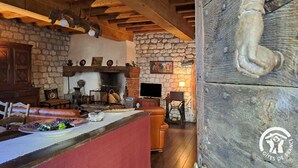 A rustic interior with a stone fireplace, wooden beams, and a cozy seating area. - La Vigneronne - CESTAYROLS (CESTAYROLS)