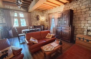 Un salon chaleureux avec un mur en pierre, des meubles en bois et une cheminée.
