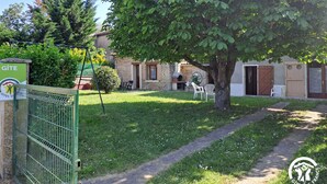 A gated property with a grassy lawn, a large tree, and a stone building with a chimney. - Les Bons Enfants - VENES (VENES)